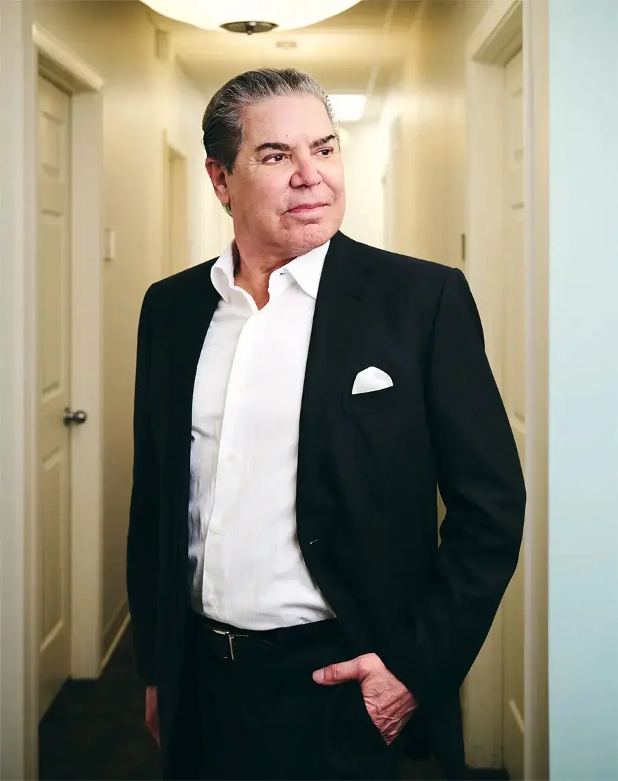 J. Michael Conkright, MD in black suit and white shirt standing confidently in modern hallway - Doctor in Evansville, IN